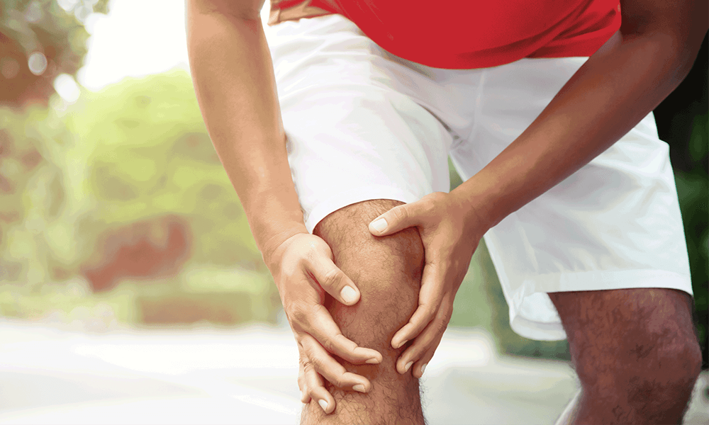 Photo of a man holding his knee in pain