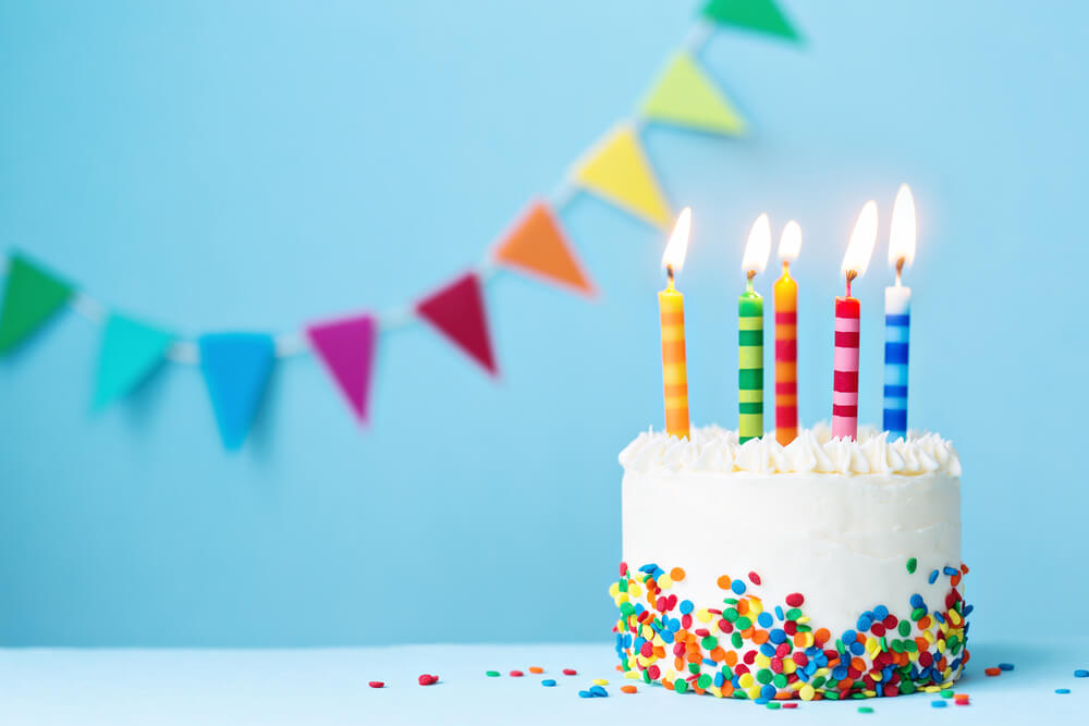 Birthday cake, candles and bunting.