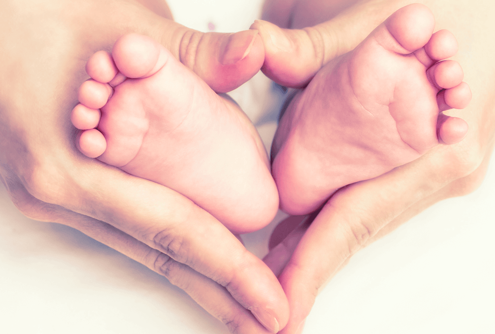 Hand heart around baby's feet