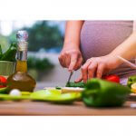 Pregnant female cutting vegetables